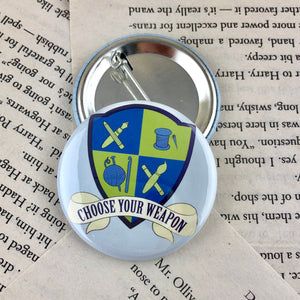 blue and green creative crest button reading "choose your weapon"