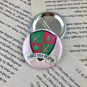 pink and green creative crest button reading "choose your weapon"